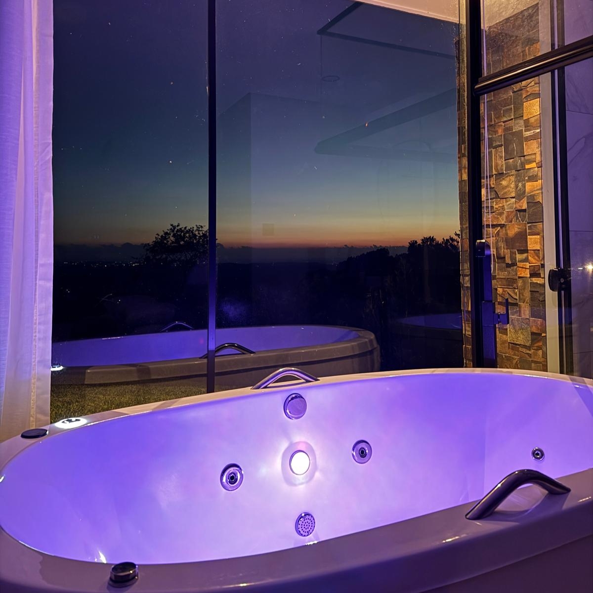 Banheira de hidromassagem com vista para o pôr do sol e ofurô externo