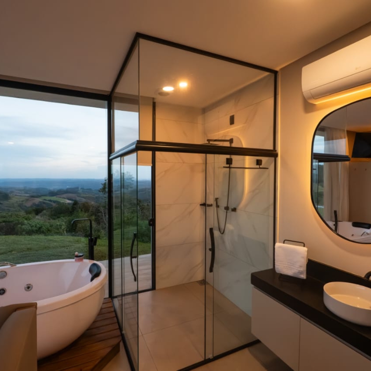 Banheiro com banheira, ducha e vista para as colinas