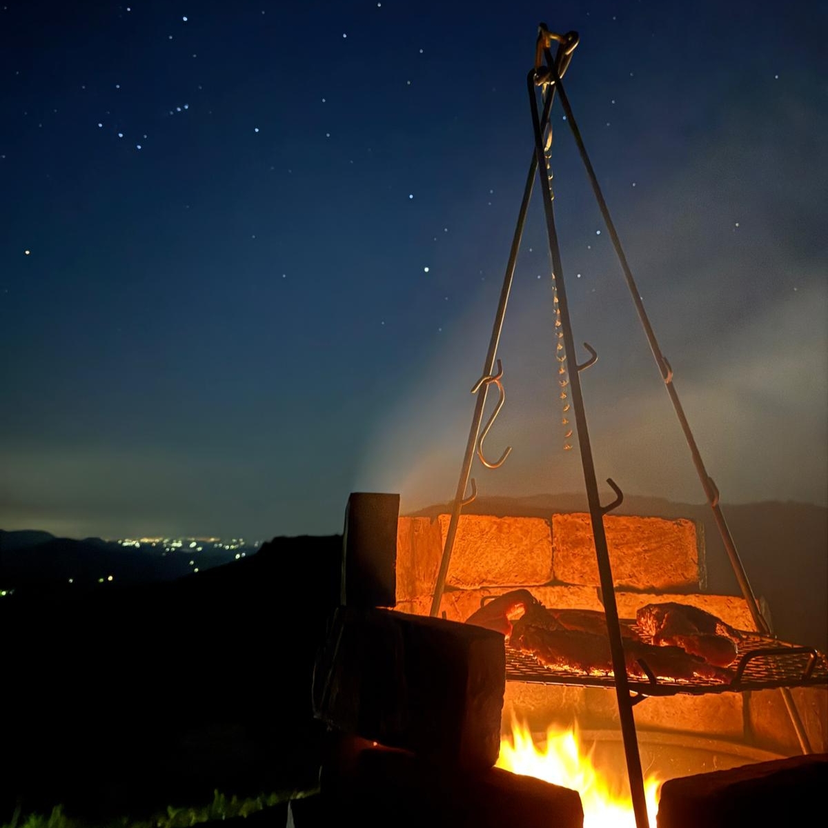 Churrasco noturno com fogo de chão sob o céu estrelado na Cabana Lúmina Colina