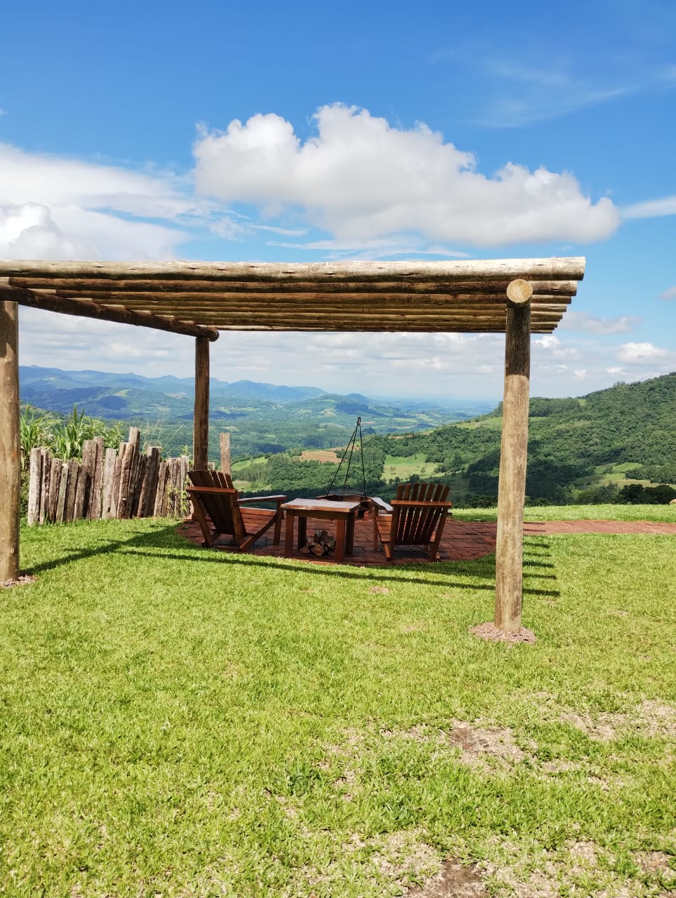 Pergolado com fogo de chão e vista panorâmica das colinas durante o dia